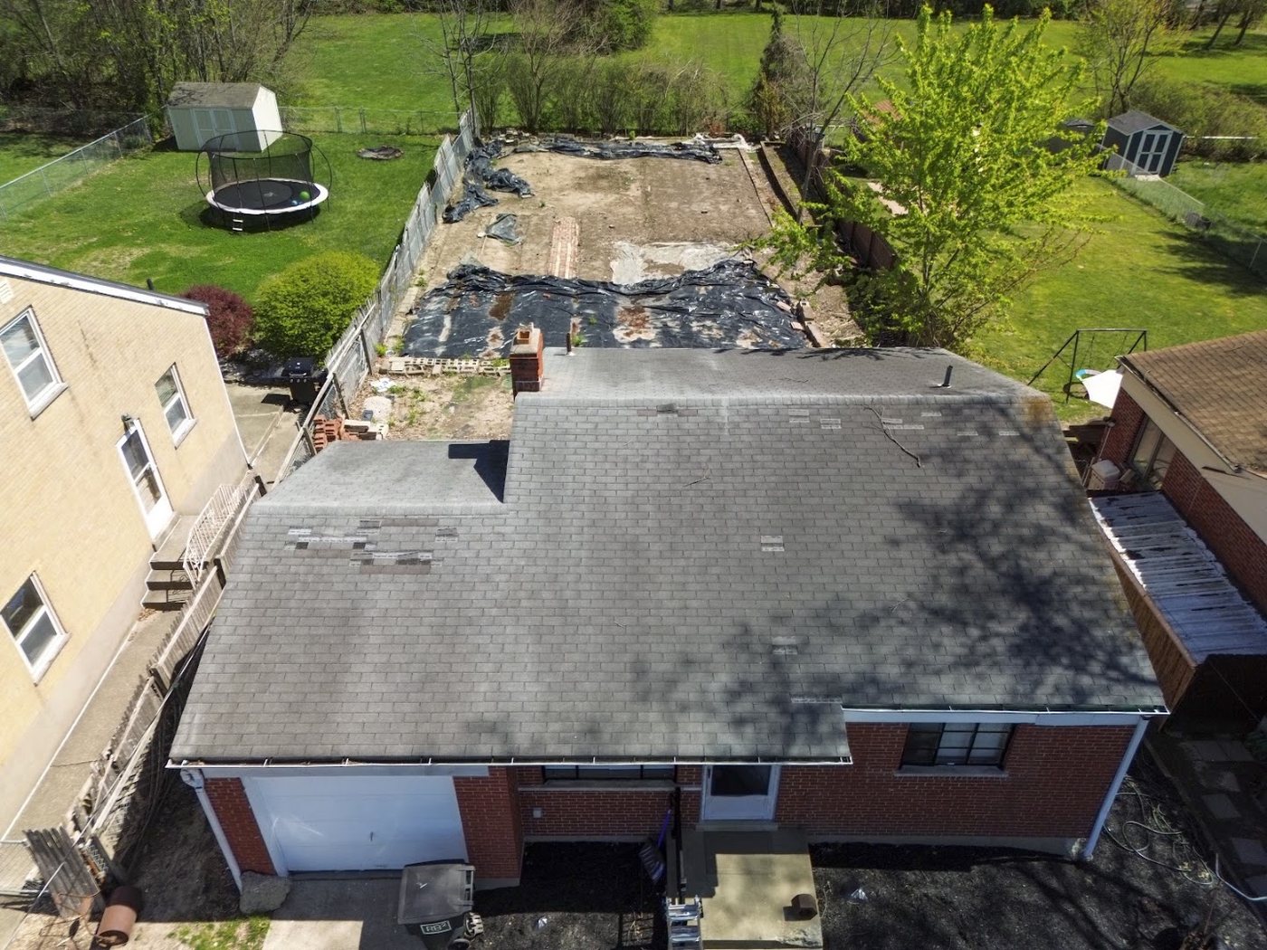 Aerial view of a roof tear-off in progress with part of the old roofing removed